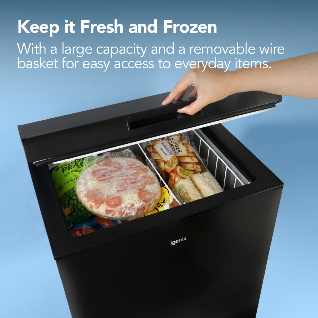 A person opens a black Igenix Freestanding Chest Freezer (99L) packed with pizza and veggies. White text above reads: Keep it Fresh and Frozen with extra freezer storage—featuring a spacious 99 litre capacity basket.