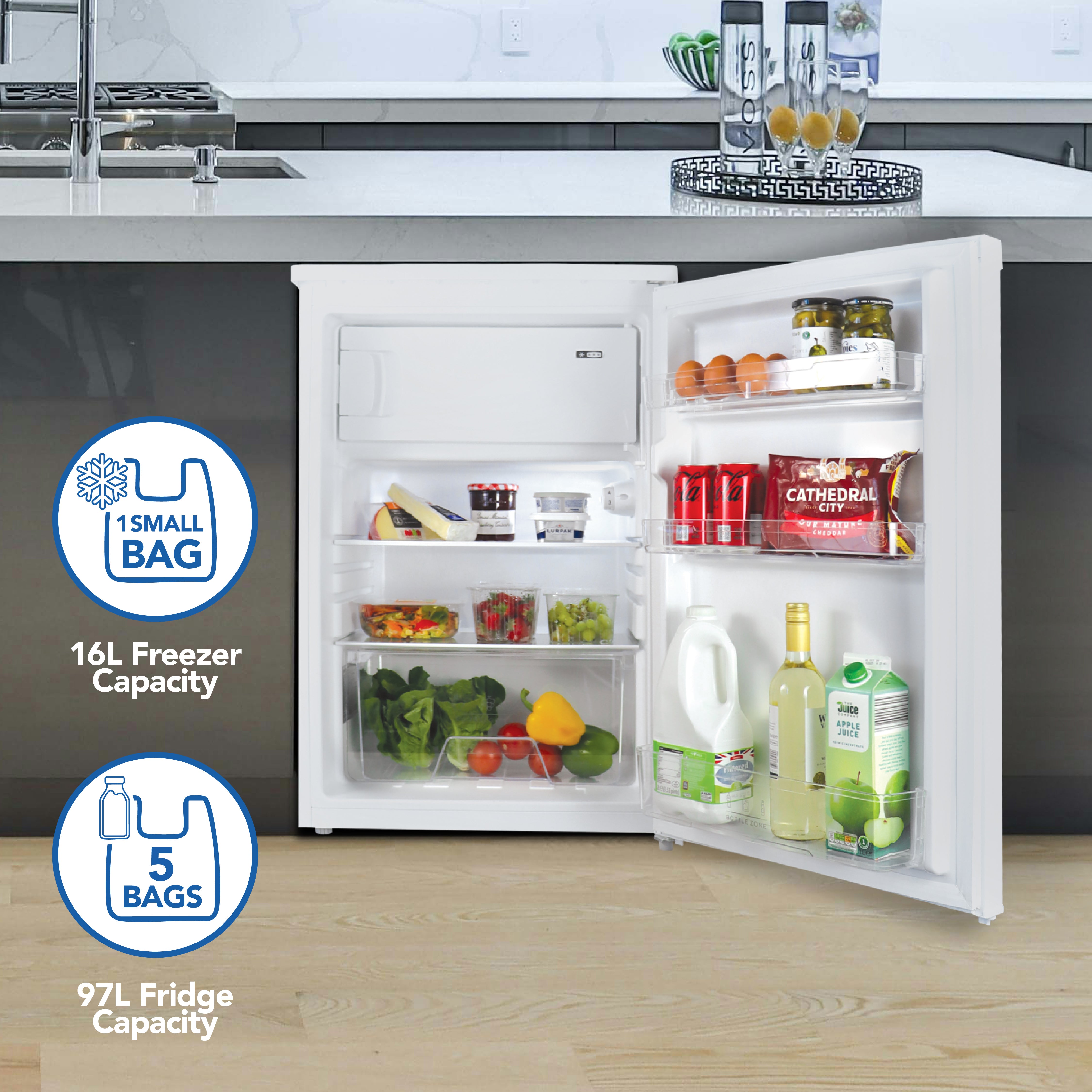 An open Igenix Under Counter Fridge with Ice Box in white shows milk, cheese, eggs, veggies, and drinks. It offers a 97L fridge for 5 bags and 16L icebox for 1 bag storage. An adjustable thermostat ensures optimum cooling.