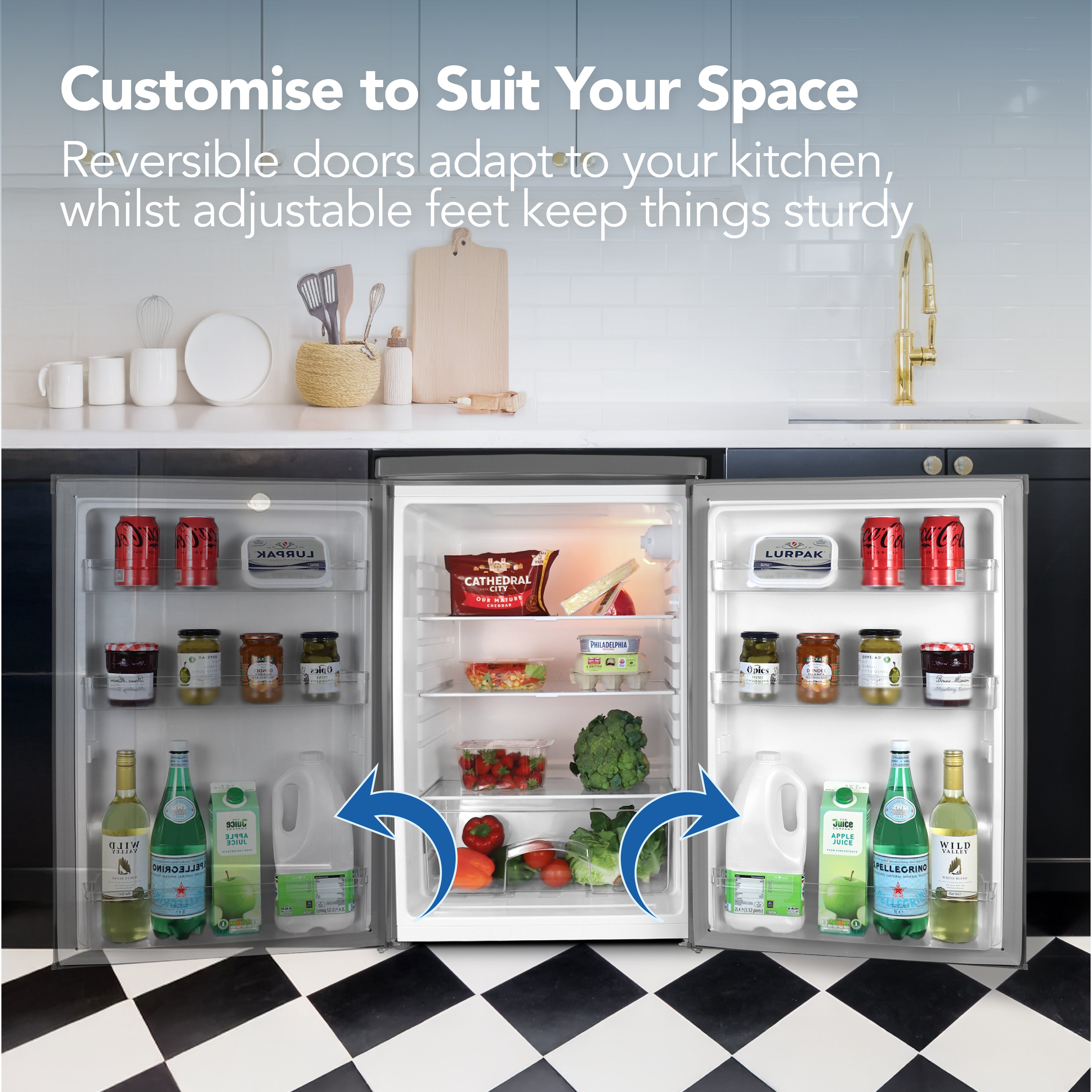 The Igenix Under Counter Larder Fridge (127L, Silver) stands in a modern kitchen with both reversible doors open, displaying milk, juice, and fresh produce. Blue arrows highlight the customizable door features.