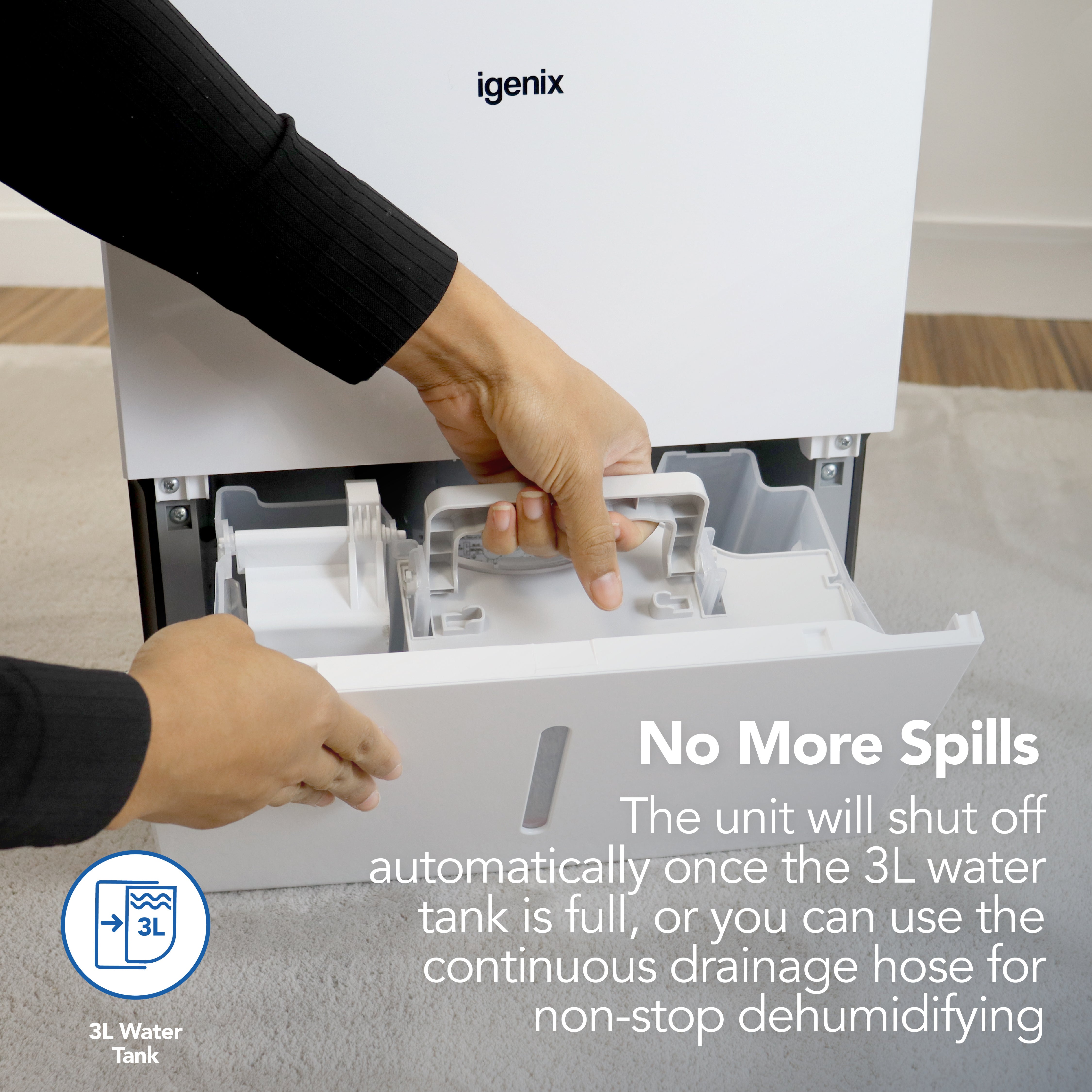 Someone removes the water tank from the Igenix Portable Dehumidifier, which extracts 30 litres per day and automatically shuts off when full. For nonstop use, attach a continuous drainage hose.