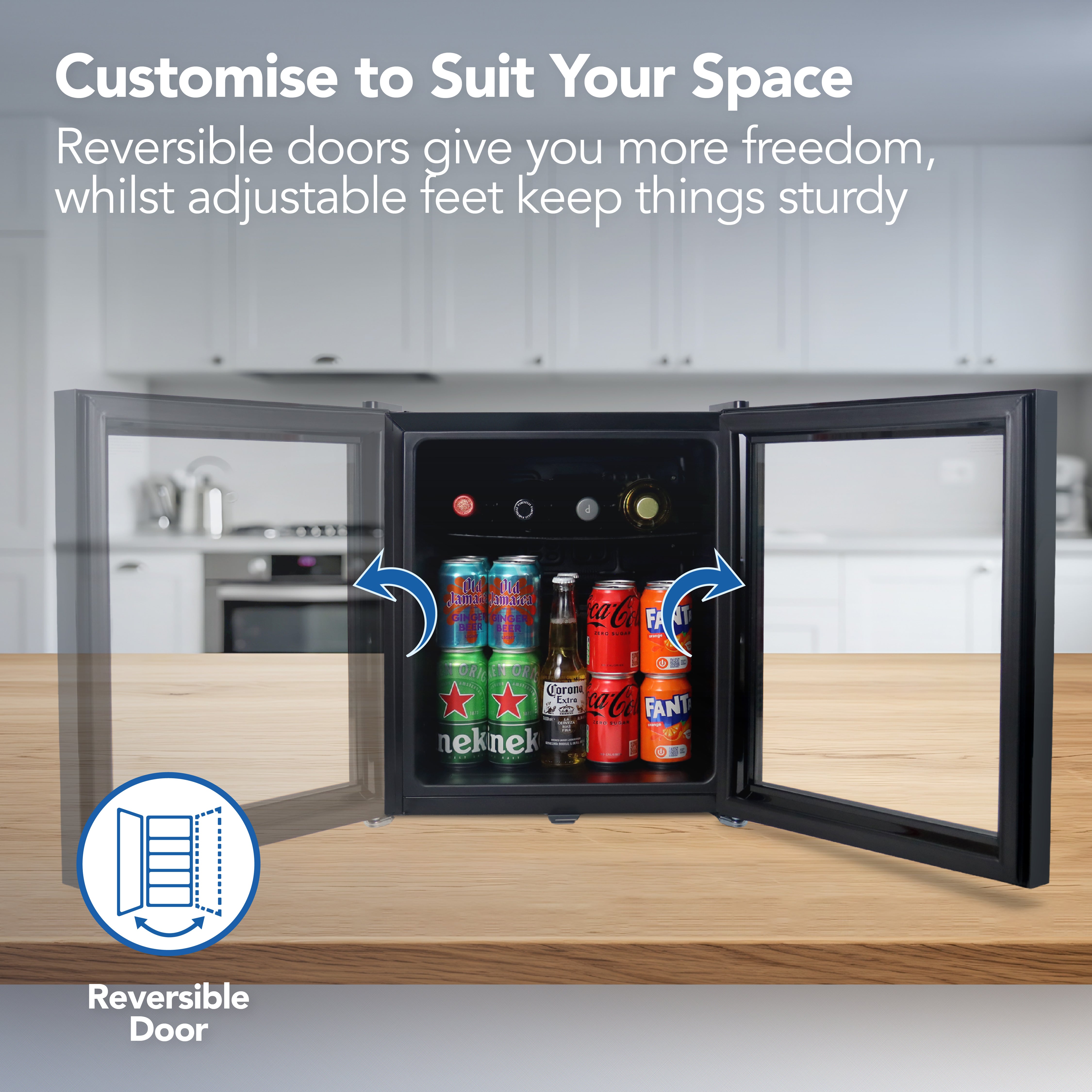 The Igenix Tabletop Drinks Fridge, 48 Litre, Black, sits on a kitchen counter with reversible doors and adjustable feet, showing cans of Heineken, Sprite, Coca-Cola, and Fanta stored inside its spacious interior.