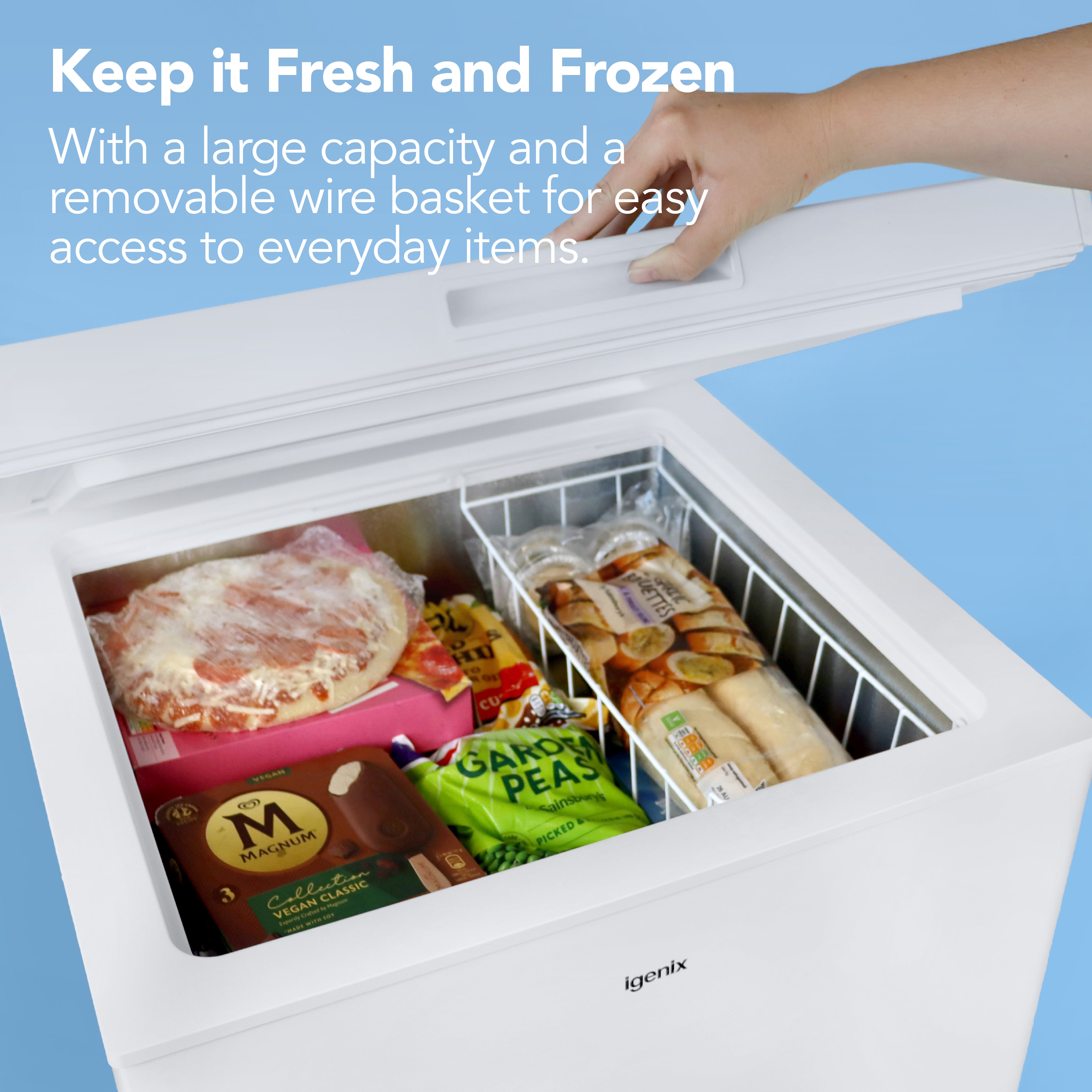 A hand opens the Igenix Freestanding Chest Freezer, 143 Litre, White, revealing pizza, ice cream, and veggies. Text highlights its spacious capacity, energy efficiency, and removable wire basket for easy access.
