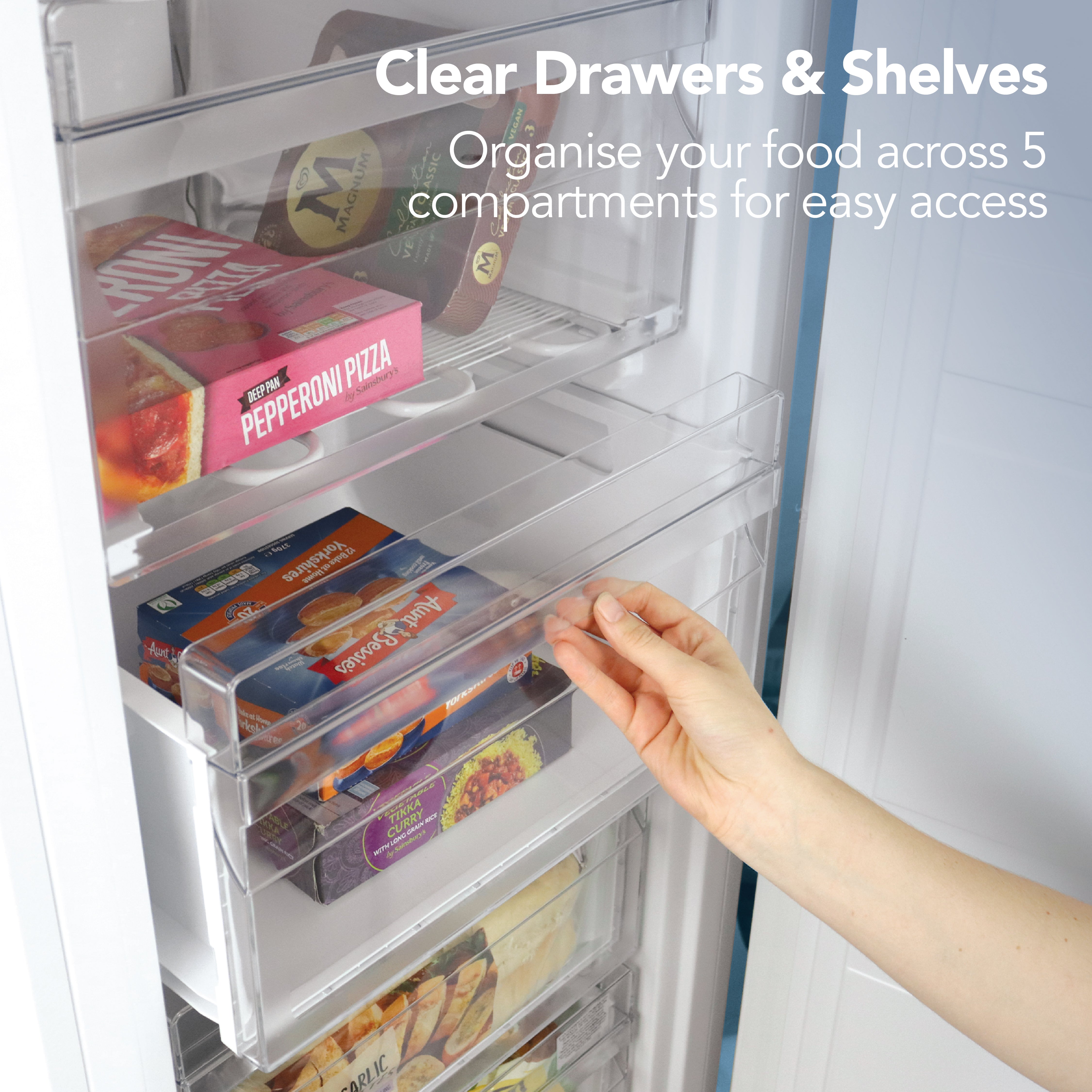 A hand opens the Igenix Freestanding Tall Freezer (55cm, 160L), revealing five transparent compartments for easy food organization with clear drawers and shelves.