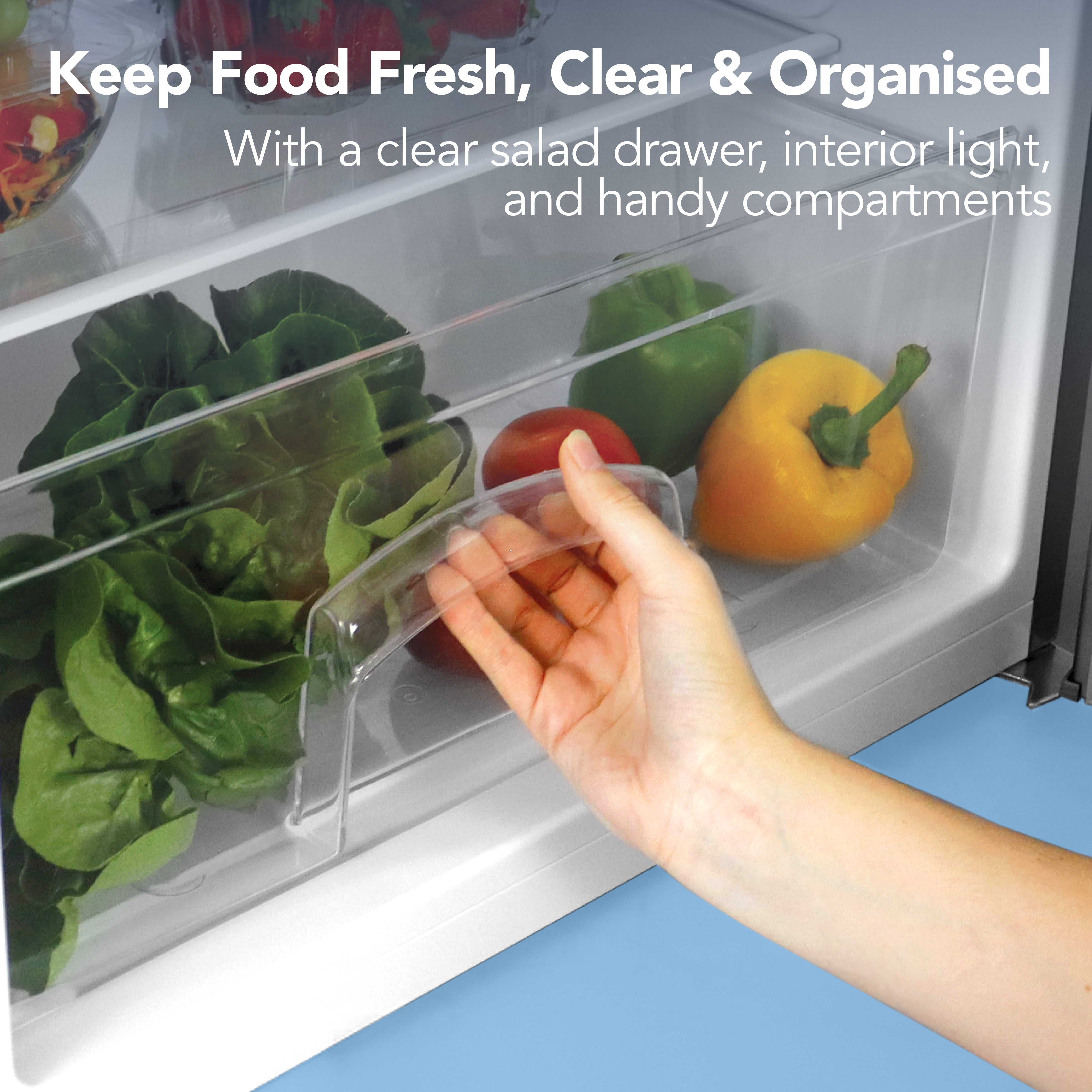 A hand opens a clear salad drawer in the Igenix Under Counter Fridge with Ice Box, Inox, revealing fresh leafy greens and bell peppers. Text above reads: Keep Food Fresh, Clear & Organised.