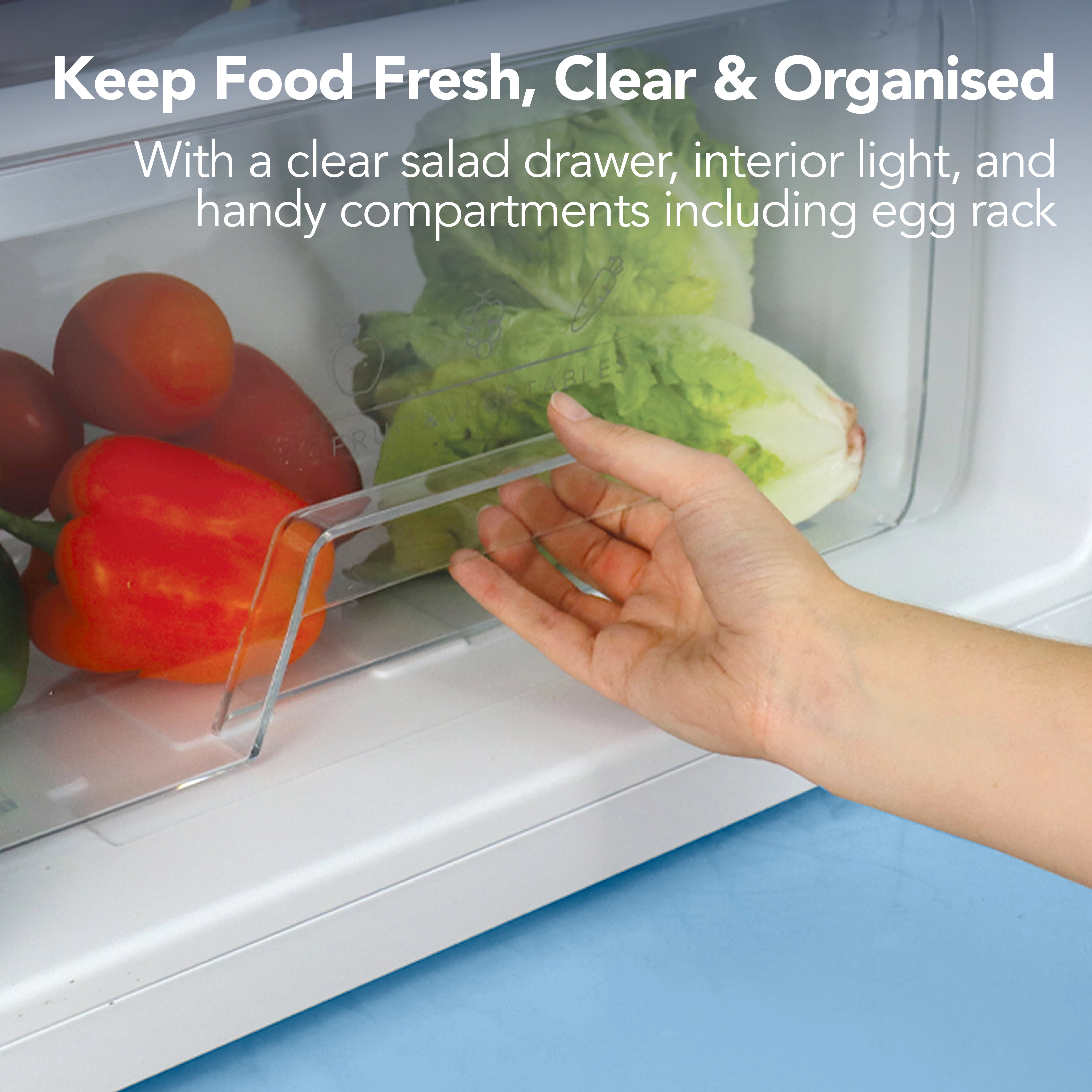 A hand opens the clear salad drawer in the Igenix Under Counter Larder Fridge (131L, White), showing fresh veggies inside. Text highlights adjustable glass shelves, interior light, egg rack, and reversible doors for flexible use.