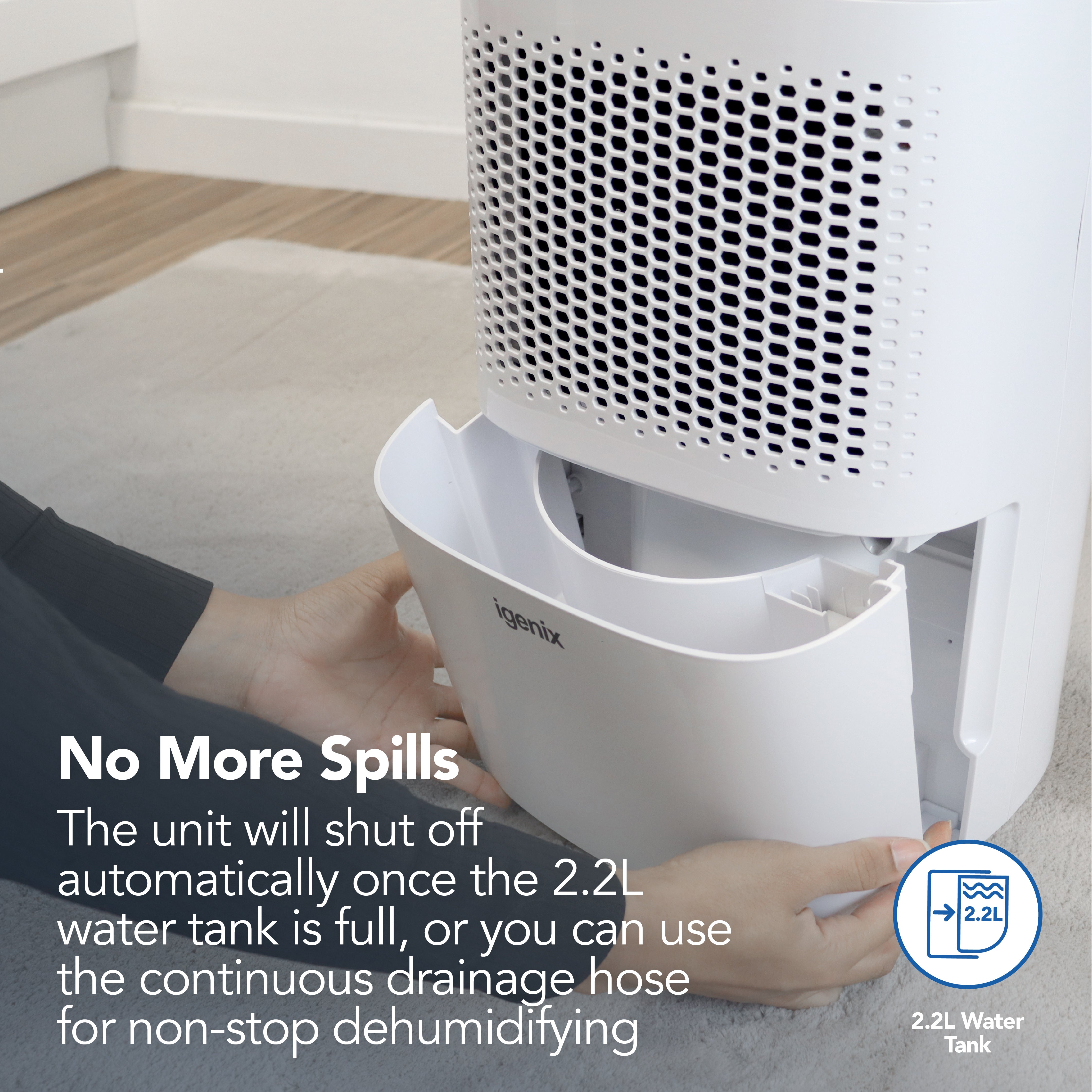 A person removes a water tank from a white Igenix Portable Dehumidifier, which extracts 12L/day. It shuts off when the 2.2L tank is full or use continuous drainage—ideal for home use. No More Spills is displayed in bold text.
