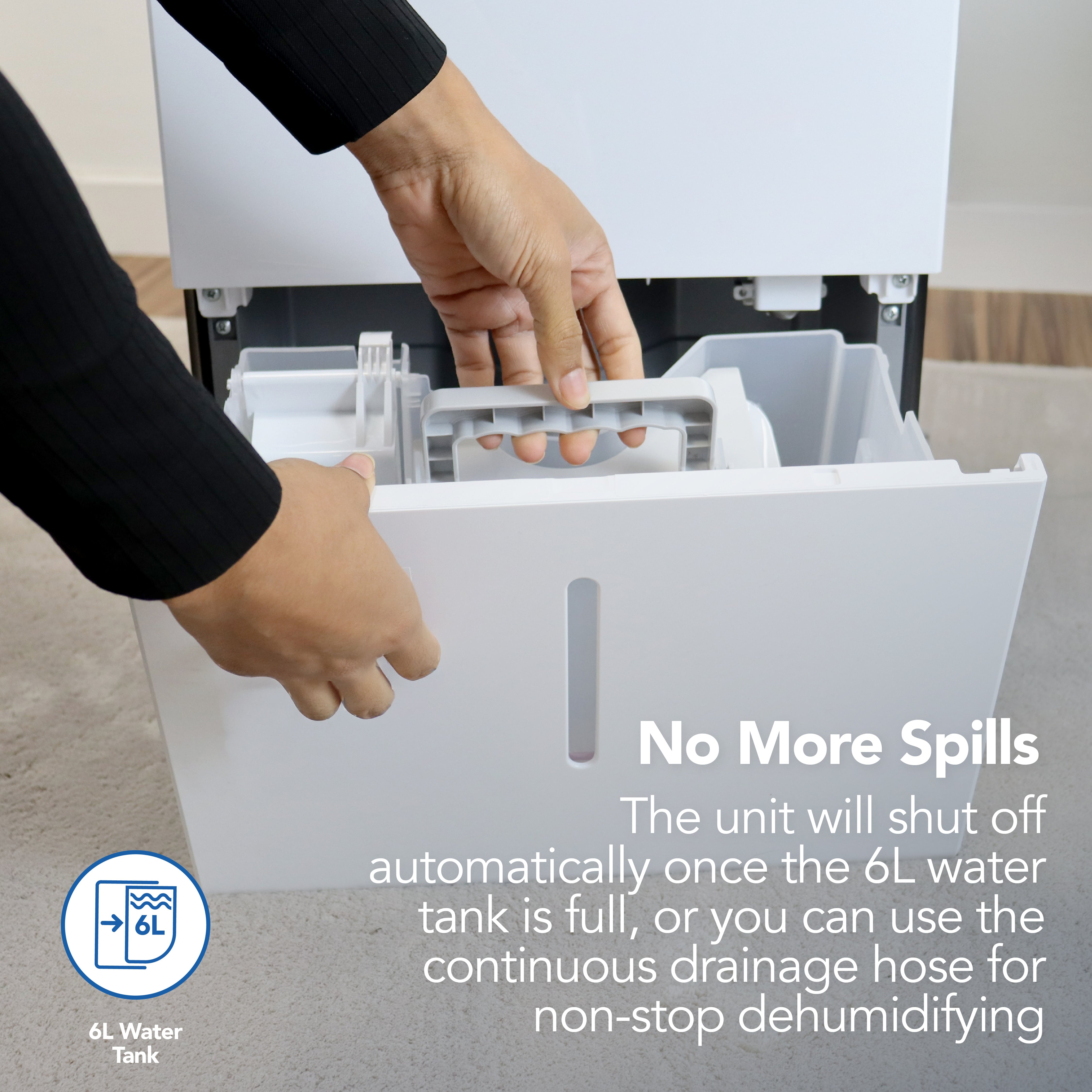 A person removes the 6L water tank from the Igenix Portable Dehumidifier, which extracts up to 50 litres daily, shuts off automatically when full, and includes a hose option for continuous drainage.