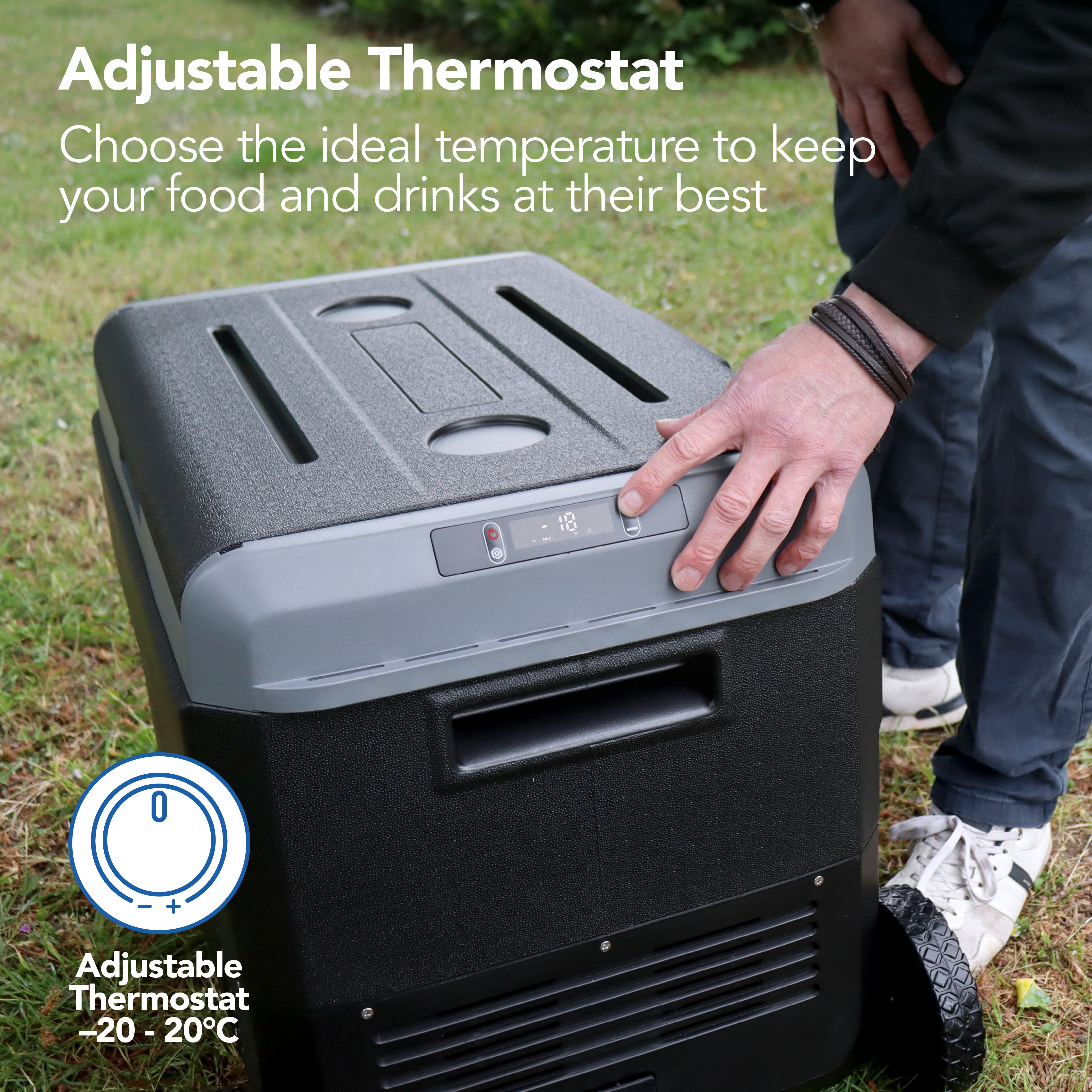 A person adjusts the temperature on the Igenix 50L Portable Fridge Freezer, Black, featuring a digital display and -20 to 20°C range—ideal for keeping food and drinks cool while camping.