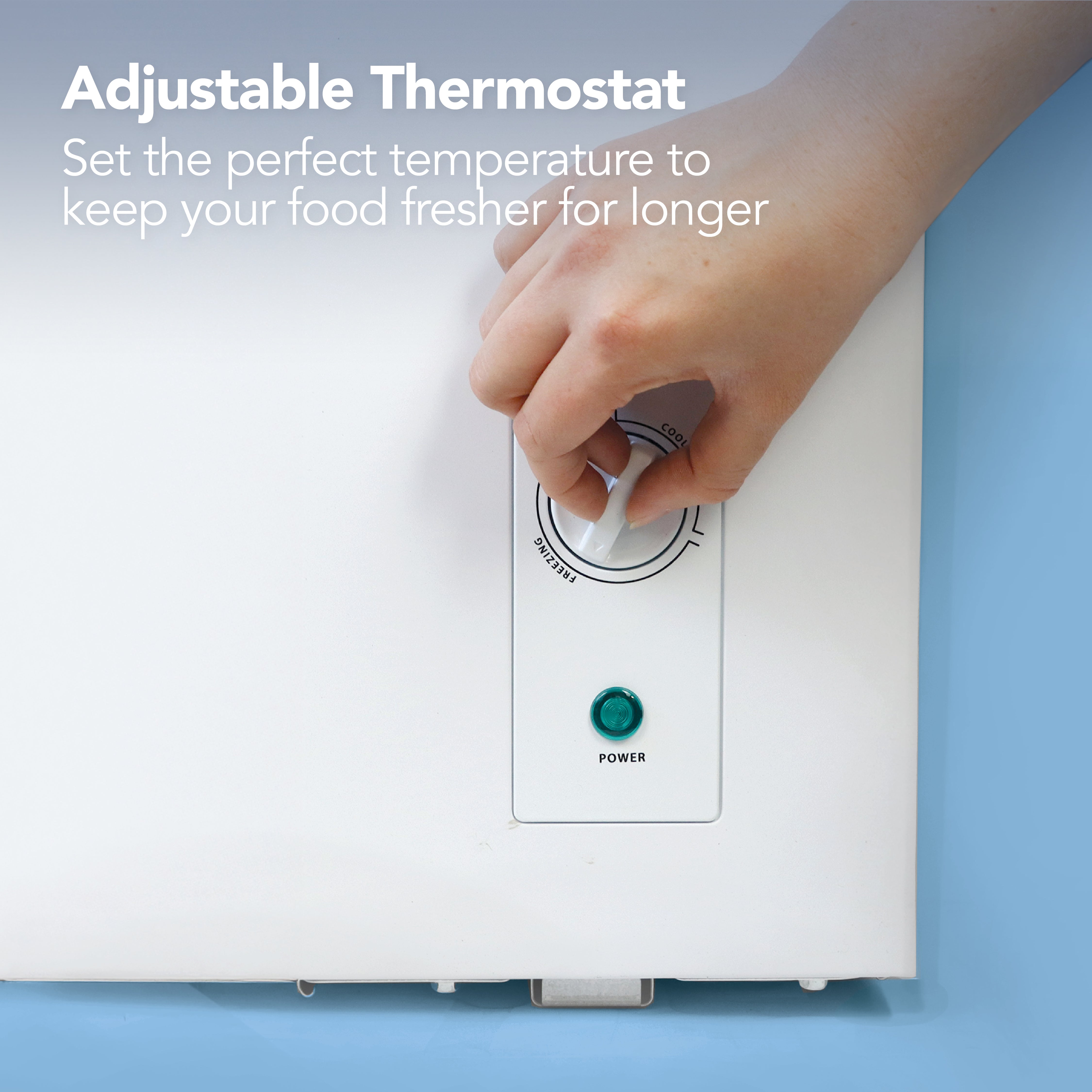 A hand adjusts the thermostat on the Igenix Freestanding Chest Freezer, 143 Litre, White, with a green power light. Text: Adjustable Thermostat. Set the ideal temperature to keep your food fresher for longer.