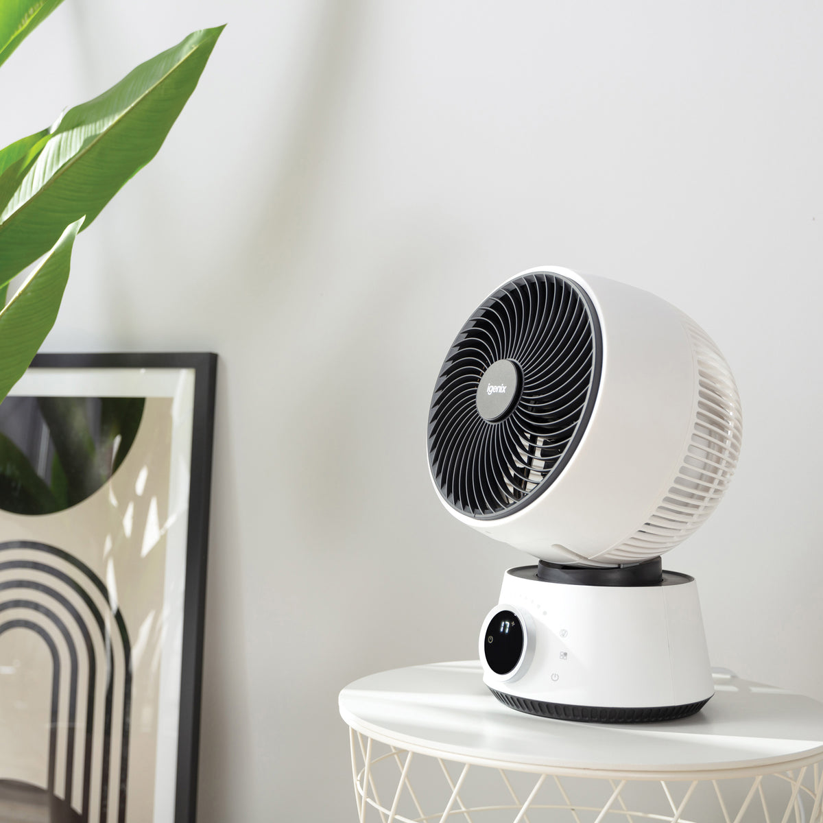 An Igenix Digital Air Circulator Turbo Fan, 9 Inch, White with a black grille sits on a small round table.