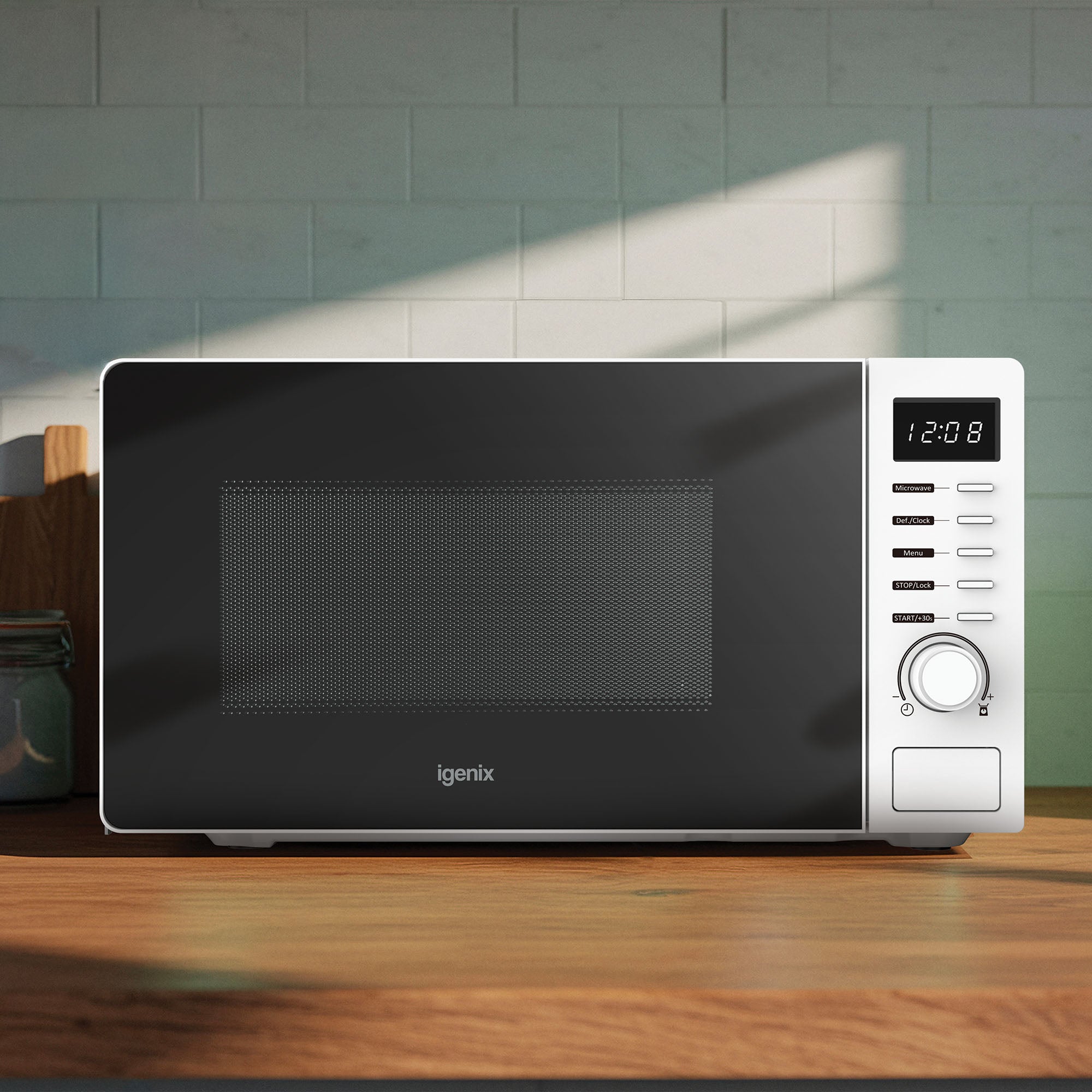 An Igenix 20L 700W digital microwave (IGMS02070W) with 8 functions and 5 power levels sits on a wooden counter, displaying 12:08 with multiple control buttons on the right.